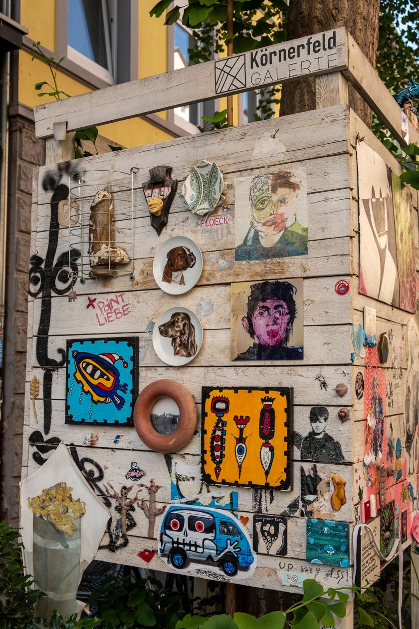 On a slatted wall, many different urban artworks can be seen.