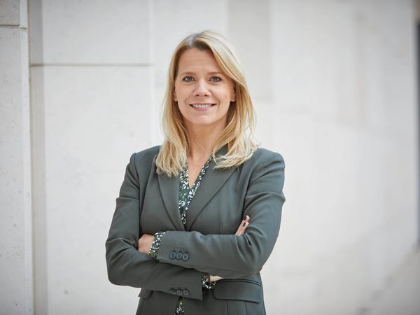 Ms. Stephanie Kleine Klausing poses confidently with a friendly smile in front of a white wall.