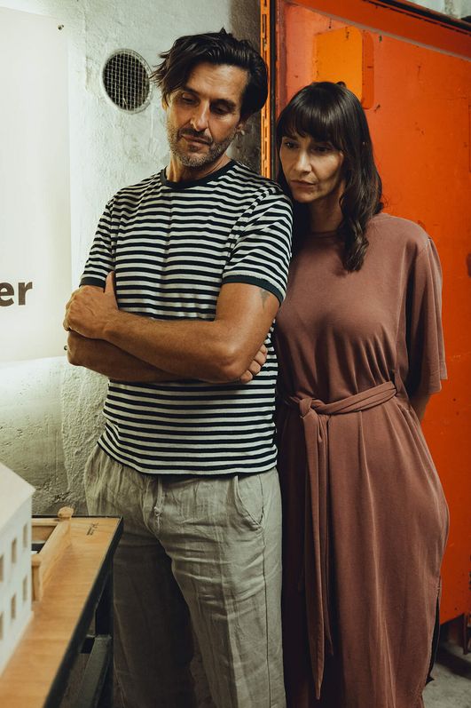 Two people are looking at a sculpture of a house.