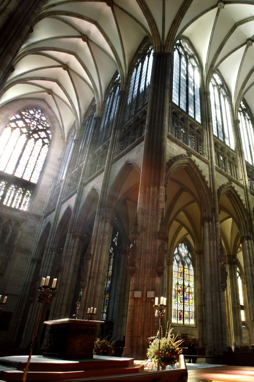 View over the altar into the interior of Cologne Cathedral. The light breaks through the cathedral windows, giving the space a mystical atmosphere.
