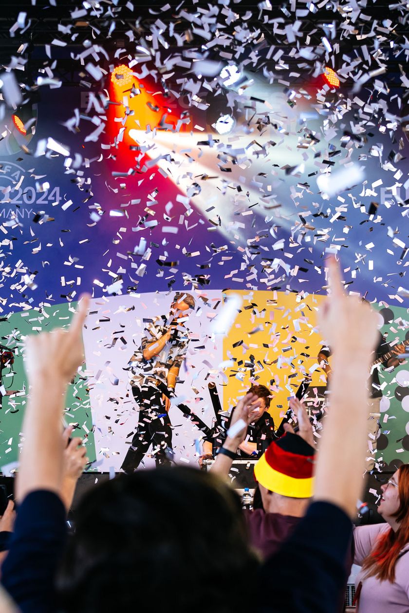 A band is playing on a stage and confetti is flying through the air.