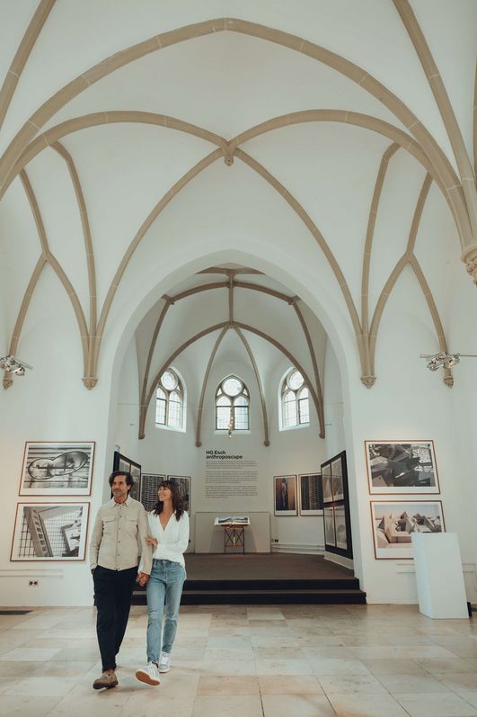 Two people walk through a bright church.